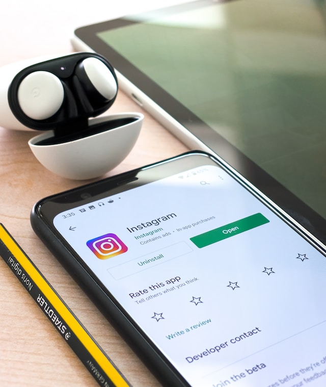 Image of a mobile device on a table with the Instagram app download screen.