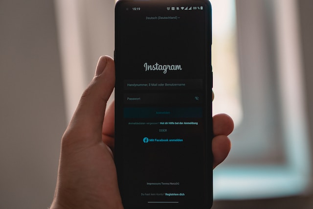 an image of a person holding the phone with the Instagram login screen open.