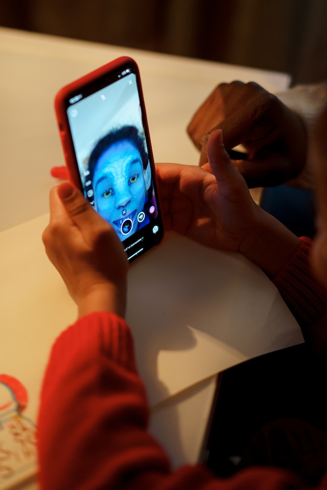 A person records a video of themself in an Avatar filter.
