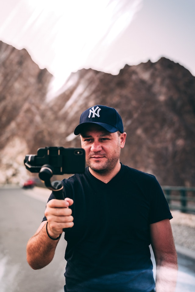 A professional photographer films outdoor content for his Instagram page.