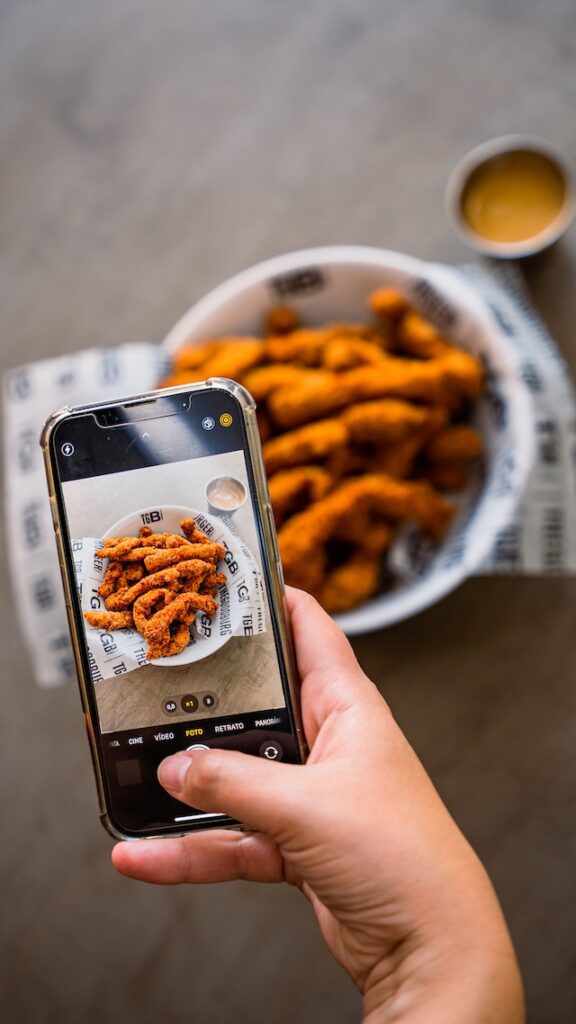 A person takes a picture of food, aiming to upload it to Instagram.
