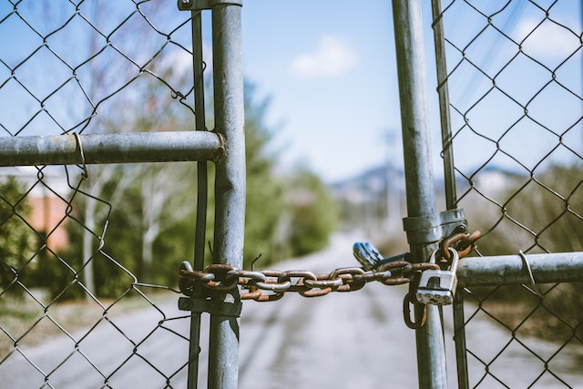 Chaîne et cadenas retenant une clôture fermée.