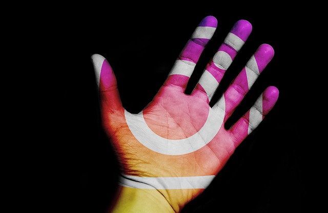 The Instagram logo projected on a person’s hand in front of a dark background.