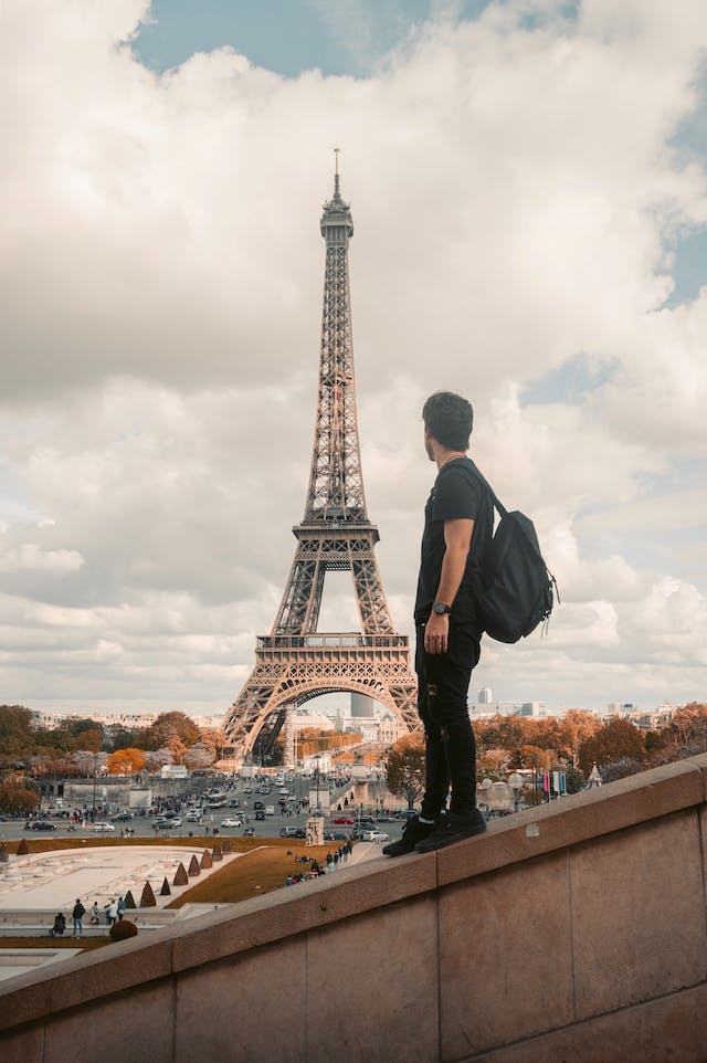 An influencer takes a photo in front of the Eiffel Tower.