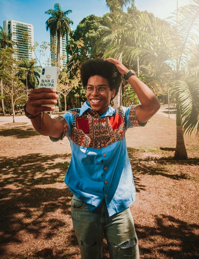 Ein Mann macht ein Selfie von seinem breiten Lächeln, während er im Freien ist.