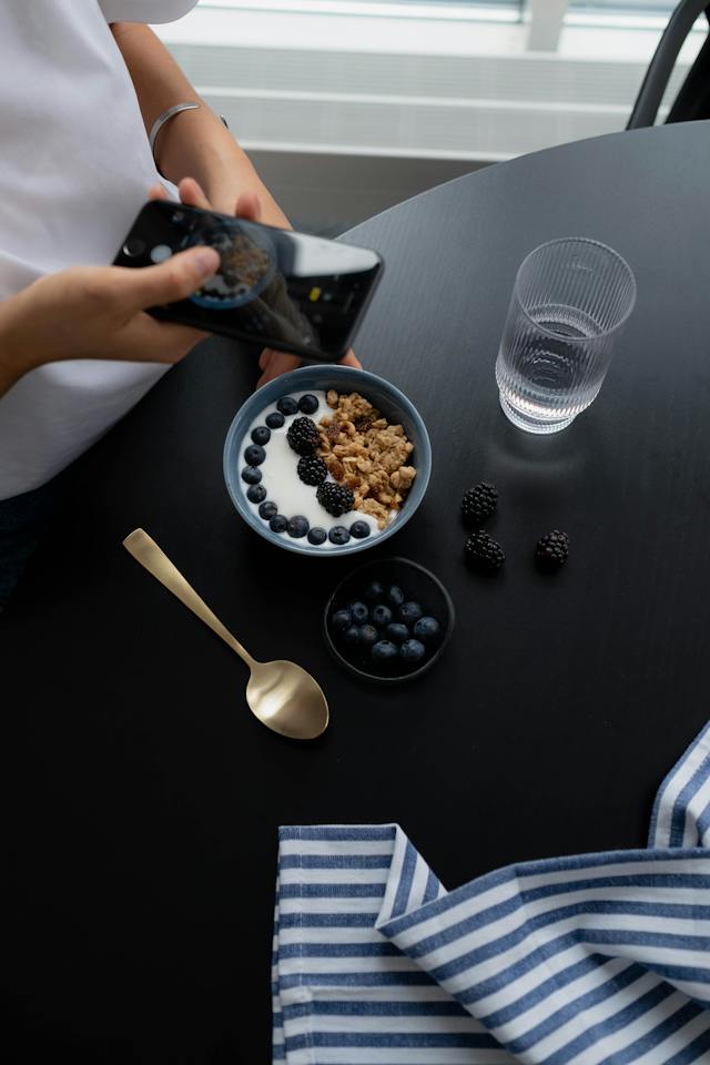 A person taking a picture of their bowl of food to post on Instagram.